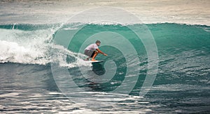 Surfer on Blue Ocean Wave, Bali, Indonesia. Riding in tube.
