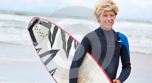 Surfer, boy and happy on beach with surfboard, vacation and adventure for fitness and travel. Ocean, waves for surfing