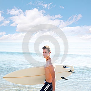 Surfer boy teenager with surfboard in beach