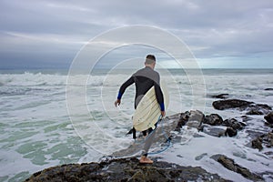 Surfer Crossing the Rocks