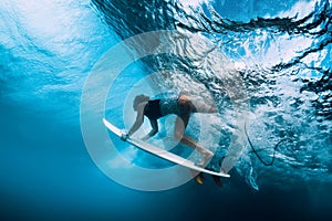 Surfer dive underwater. Surfgirl dive under wave