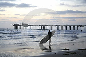 Surfer at Dusk in Front of the Scripps Pier in La Jolla, California