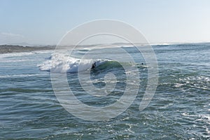 Surfer enjoying a surf session at Sao Torpes Beach in Sines on the Alentejo Coast