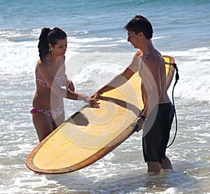 Surfer explains theory of surfing to a young woman