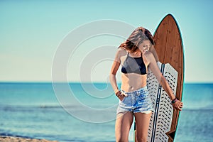 surfer girl at the beach with her surfboard Vacation. Extre