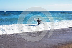 Surfer girl holding surfboard on background sea scape, sand beach coastline. Panorama horizon perspective view ocean, sunlight