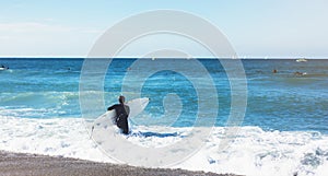 Surfer girl holding surfboard on background sea scape, sand beach coastline. Panorama horizon perspective view ocean, sunlight