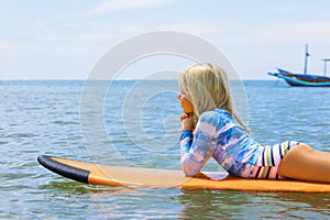 Surfer girl relaxing on surfboard