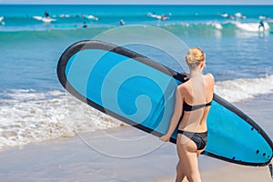 Surfer girl on the sandy beach. Surfer girl. Beautiful young woman at the beach. water sports. Healthy Active Lifestyle. Surfing.