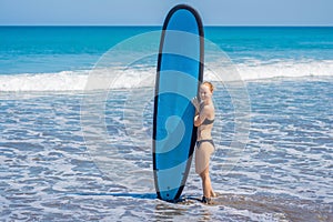 Surfer girl on the sandy beach. Surfer girl. Beautiful young woman at the beach. water sports. Healthy Active Lifestyle. Surfing.