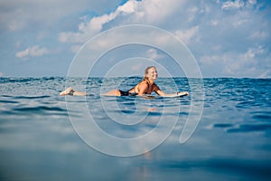 Surfer girl on the surfboard. Woman with surfboard in ocean. Surfer and ocean