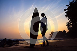 Surfer girl surfing looking at ocean beach sunset. Silhouette w