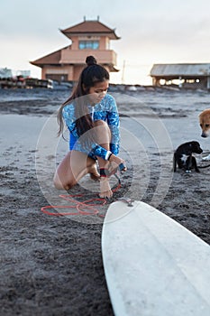 Surfer Girl. Surfing Woman On Sandy Beach With Surfboard And Dog. Asian Female In Blue Wetsuit Going To Surf In Ocean.