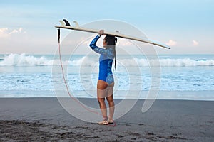 Surfer Girl. Surfing Woman With Surfboard On Head Standing On Sandy Beach. Brunette In Blue Wetsuit Going To Surf In Sea.