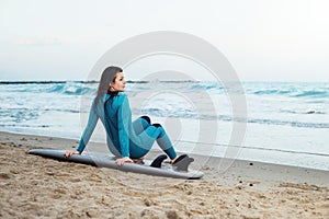 Surfer girl walking with board on the sandy beach. Surfer female.Beautiful young woman at the beach. water sports. Healthy Active