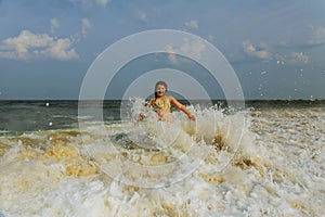 A surfer girl watching sunset on a surboard floating in green blue ocean