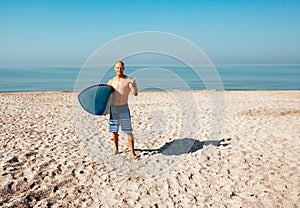 Surfer is going to surf in the ocean in a sunny day