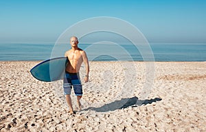 Surfer is going to surf in the ocean in a sunny day