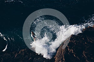 Surfer jumping in waves of ocean