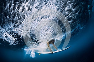 Surfer make duck dive underwater. Surfgirl dive under wave