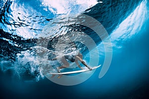 Surfer make duck dive underwater. Surfgirl dive under wave