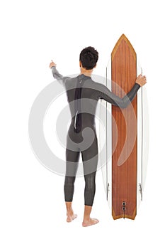 Surfer man holding a surfboard and point somewhere
