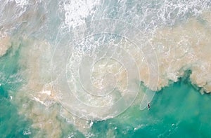 A surfer man paddles across waves in Hong Kong