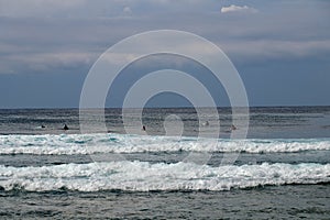 Surfer in the ocean waiting for a wave. Surfers waiting for good surfing waves. Surfers waiting for their wave. Young man waiting