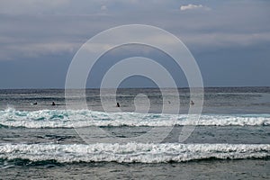 Surfer in the ocean waiting for a wave. Surfers waiting for good surfing waves. Surfers waiting for their wave. Young man waiting