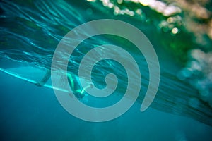 Surfer passes the wave by diving, fuerteventura island