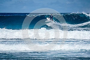 Surfer on perfect blue aquamarine wave, empty line up, perfect for surfing, clean water, Indian Ocean