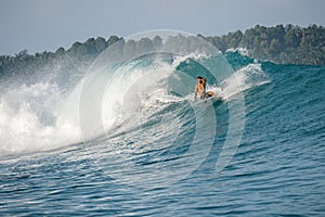 Surfer on perfect blue big tube wave, empty line up, perfect for surfing, clean water, Indian Ocean in Mentawai islands