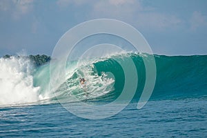 Surfer on perfect blue big tube wave, empty line up, perfect for surfing, clean water, Indian Ocean in Mentawai islands