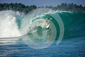 Surfer on perfect blue big tube wave, empty line up, perfect for surfing, clean water, Indian Ocean in Mentawai islands