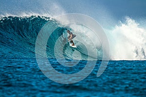 Surfer on perfect blue wave, in the barrel, clean water, Indian Ocean