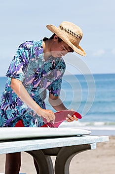 Surfer putting in a surf fin to a surfboard in Japan