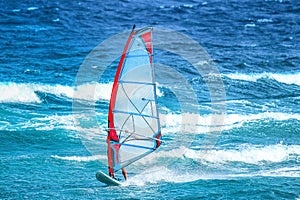 Surfer with red and blue sail