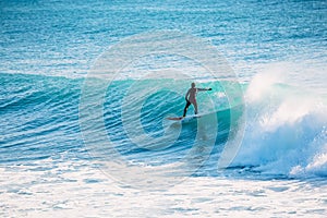 Surfer ride on blue wave. Winter surfing in ocean