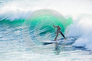Surfer ride on stand up paddle board on ocean big wave. Stand up paddle boarding in ocean