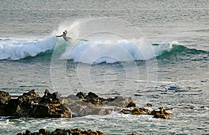 Surfer riding on the breaking waves in Pacific Ocean at Hanga Roa, Easter Island, Chile