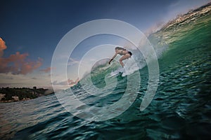 A surfer riding on green ocean wave