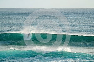 Surfer riding on the huge waves in Pacific ocean at Hanga Roa, Easter island, Chile, South America