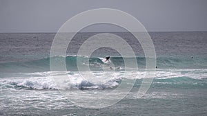 Surfer riding and turning with spray on blue ocean wave, surfing ocean lifestyle, extreme sports. Big waves with white