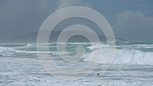 Surfer riding and turning with spray on blue ocean wave, surfing ocean lifestyle, extreme sports. Big waves with white