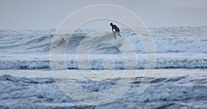 A surfer is riding a wave on a green surfboard