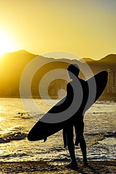 Surfer silhouette with his longboard