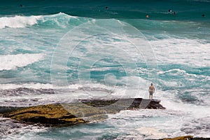 Surfer standing on a rock