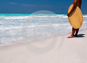 Surfer standing on a tropical beach