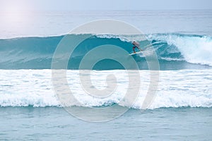 Surfer stands in a tube. Surfer gettting barreled