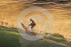 Surfer at sunset at Honolua Bay on Maui.
